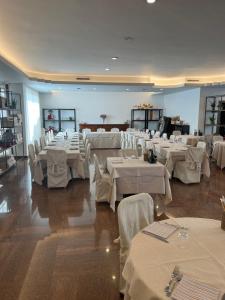 une salle de banquet avec des tables blanches et des chaises blanches dans l'établissement Albergo Alla Speranza, à Castelfranco Veneto