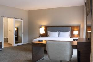 Habitación de hotel con cama y escritorio con lámpara. en Hampton Inn & Suites Boerne, en Boerne