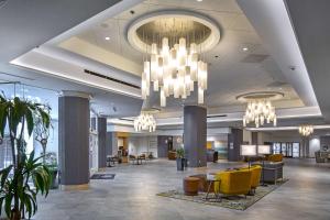 a lobby with yellow chairs and chandeliers at DoubleTree by Hilton Modesto in Modesto