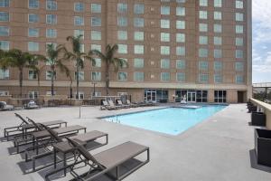 a swimming pool with lounge chairs and a building at DoubleTree by Hilton Modesto in Modesto