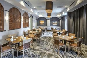 a dining room with wooden tables and chairs at DoubleTree by Hilton Modesto in Modesto