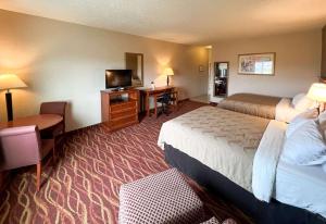 a hotel room with two beds and a flat screen tv at Quality Inn & Suites Grants - I-40 in Grants