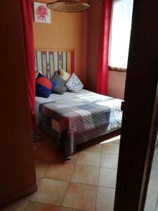 een kleine slaapkamer met een bed met kleurrijke kussens bij Bel appartement à Oualidia in Oualidia