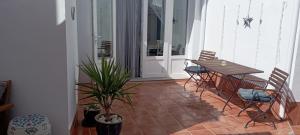 une terrasse couverte avec une table, des chaises et une plante dans l'établissement Casa Rural Olivares, à Villanueva de Algaidas