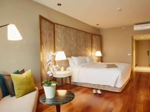 Un dormitorio con una cama y una mesa con un ordenador portátil. en Manto Hotel Lima - MGallery, en Lima