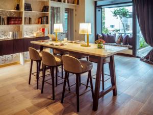 une salle à manger avec une grande table et des chaises en bois dans l'établissement Manto Hotel Lima - MGallery, à Lima