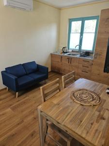 - un salon avec une table et un canapé bleu dans l'établissement Kamp Brda Camping and rooms, à Kojsko