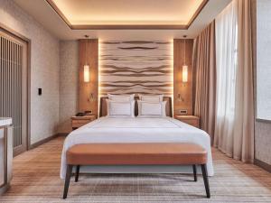 1 dormitorio con 1 cama grande con almohadas blancas en Swissotel Uludag Bursa en Bursa