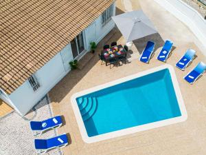 einen Blick über einen Pool mit Stühlen und einem Sonnenschirm in der Unterkunft Villa Oahu by Algarve Vacation in Albufeira