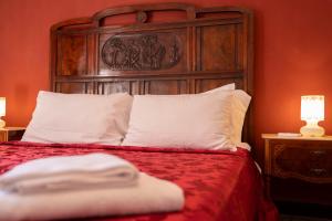 a bed with a wooden headboard and white pillows at WELL COME - Santa Lucia in Naples