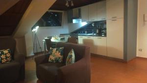 a living room with two chairs and a kitchen at Loft Belvedere in Sulmona