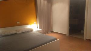 a bedroom with a bed and a yellow wall at Loft Belvedere in Sulmona
