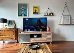 - un salon avec une télévision et une table en bois dans l'établissement Appartement quartier calme. Proche Port et plages., à Saint-Brieuc