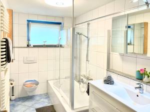 La salle de bains est pourvue d'une douche, d'une baignoire et d'un lavabo. dans l'établissement Seemöwe, à Uhldingen-Mühlhofen