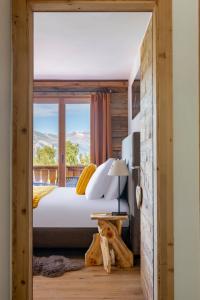 a bedroom with a bed and a window with a view at PAPILL'ON - Boutique Hotel in La Tzoumaz