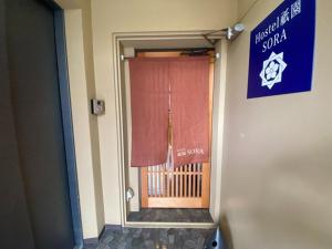 a door to a room with a window and a sign at Higashi Shimbashi Building 3F Hostel Gion SORA - Vacation STAY 92728v in Kyoto