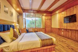 a bedroom with a bed and a tv and a window at Solang Cottage By Snow City Farm in Palchān