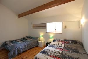1 dormitorio con 2 camas y ventana en Belle maison de village sur theziers, en Théziers