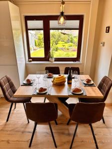 a dining room table with chairs and a large window at Vila Minka Bled - Perfect Family Vacation Home in Bled