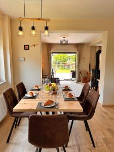 a dining room with a large wooden table and chairs at Vila Minka Bled - Perfect Family Vacation Home in Bled