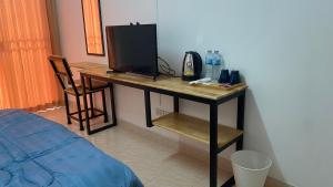 a room with a desk with a television and a bed at ธนทรัพย์ อพาร์ทเม้นท์ Room03 in Ban Bang Kadi Pathum Thani