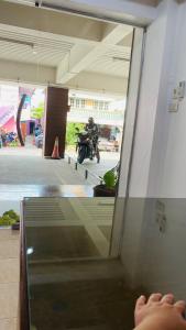 a person is riding a motorcycle in a building at ธนทรัพย์ อพาร์ทเม้นท์ Room03 in Ban Bang Kadi Pathum Thani