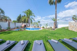 einen Hinterhof mit einem Pool mit Liegen in der Unterkunft Villa Jazz Marbella with 7 bedrooms in Marbella
