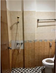 La salle de bains est pourvue d'une douche et de toilettes. dans l'établissement Belvena Makati Hotel, à Sukarami