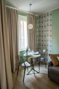 un soggiorno con tavolo, sedie e finestra di SAN PIO a Torino
