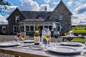 a table with wine glasses and a bottle of wine at House - Private use in Sedbergh