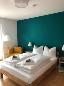 ヴュルツブルクにあるNette Apartments in Würzburgの緑の壁の客室の大型ベッド1台