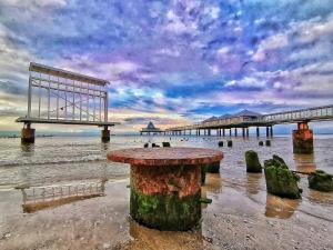 een uitzicht op een pier met een tafel in het water bij Villa Sabinium in Heringsdorf