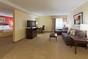 ein Hotelzimmer mit einem Sofa, einem Bett und einem TV in der Unterkunft Holiday Inn Express Fort Lauderdale North - Executive Airport, an IHG Hotel in Fort Lauderdale