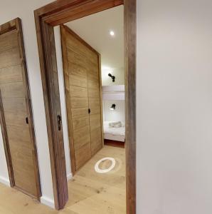 a hallway with a wooden door and a bedroom at Appartement neuf à Mottaret / A12 in Les Allues