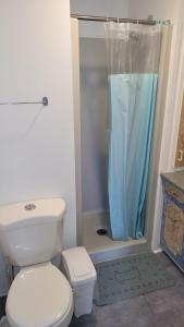 y baño con aseo y ducha. en Cozy quiet place next to hwy smart tv+wifi+netflix, en Edmundston