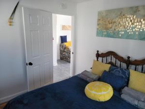 - une chambre avec un lit bleu et un canapé dans l'établissement Cozy quiet place next to hwy smart tv+wifi+netflix, à Edmundston
