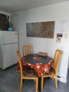 a table and two chairs with a table and a refrigerator at Cozy quiet place next to hwy smart tv+wifi+netflix in Edmundston