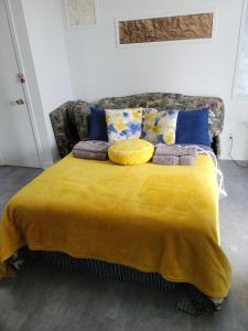 - un lit avec une couverture jaune et des oreillers dans l'établissement Cozy quiet place next to hwy smart tv+wifi+netflix, à Edmundston