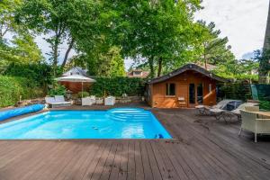 una piscina en una terraza de madera con una casa en Luxury Hideaway with Pool and Sauna, en Kleinmachnow