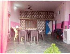 une salle à manger avec des chaises et une table dans une pièce dans l'établissement RUDRAKSH HOTEL AND GUEST HOUSE, Ayodhya, à Ayodhya