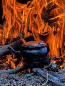 a pot sitting on top of a fire with flames at Mishari Wadi Rum camp in Disah