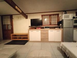 a kitchen with white cabinets and a refrigerator at Gîte chez Kaky in Onesse-et-Laharie
