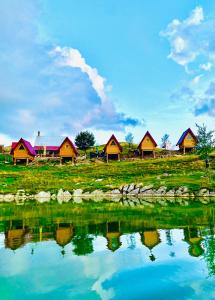 a group of houses next to a body of water at Kapetanovo Jezero Bungalov in Podgorica