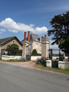 uma casa com um portão de ferro forjado e uma cerca em Ferme de La Croix em Brion-près-Thouet