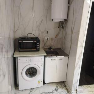 a small kitchen with a microwave and a washing machine at Dream in Vračar (historical) +7 photos