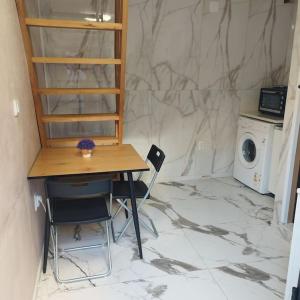 a room with a table and chairs and a washing machine at Dream in Vračar (historical)