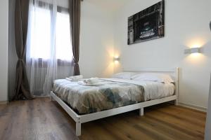 a white bed in a room with a large window at Free parking 7 minutes from the Euganean Hills in Battaglia Terme