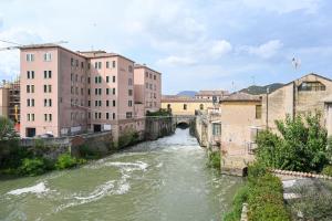 un ponte su un fiume in una città con edifici di Vicino ospedali e colli - vista sul torrente rilassante a Battaglia Terme