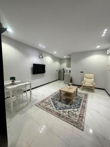 uma sala de estar com uma mesa e uma televisão na parede em المسك للوحدات الفندقيه الفاخره em Medina