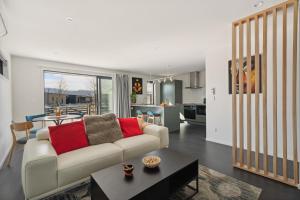 a living room with a white couch and a kitchen at Holiday in a paradise in Wanaka